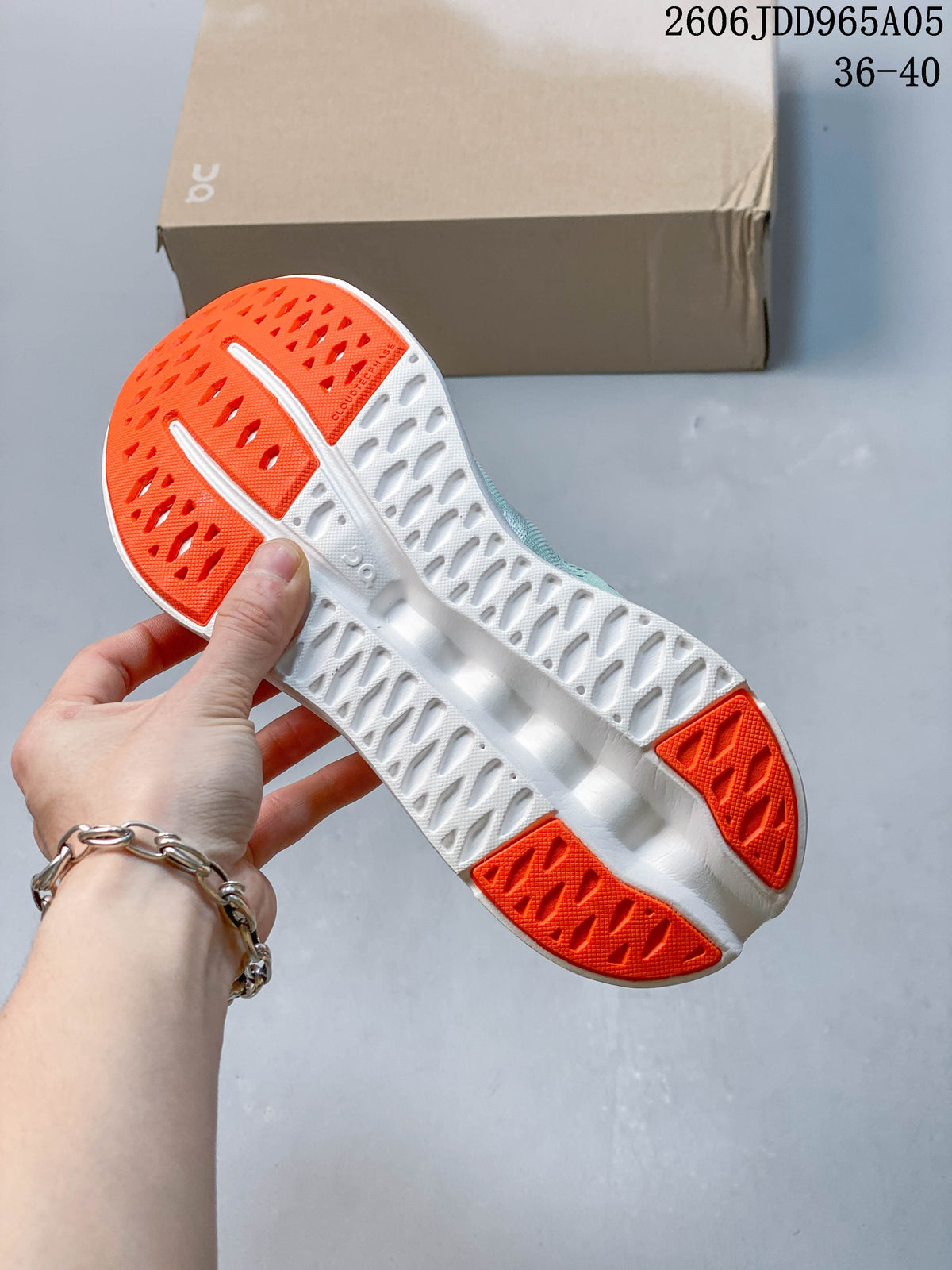 Underside of the shoe showing a white sole with orange rubber sections