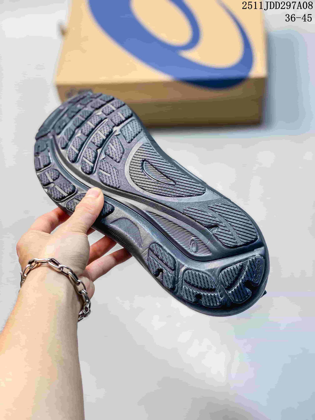 Underside of a dark charcoal running sneaker showing patterned outsole tread