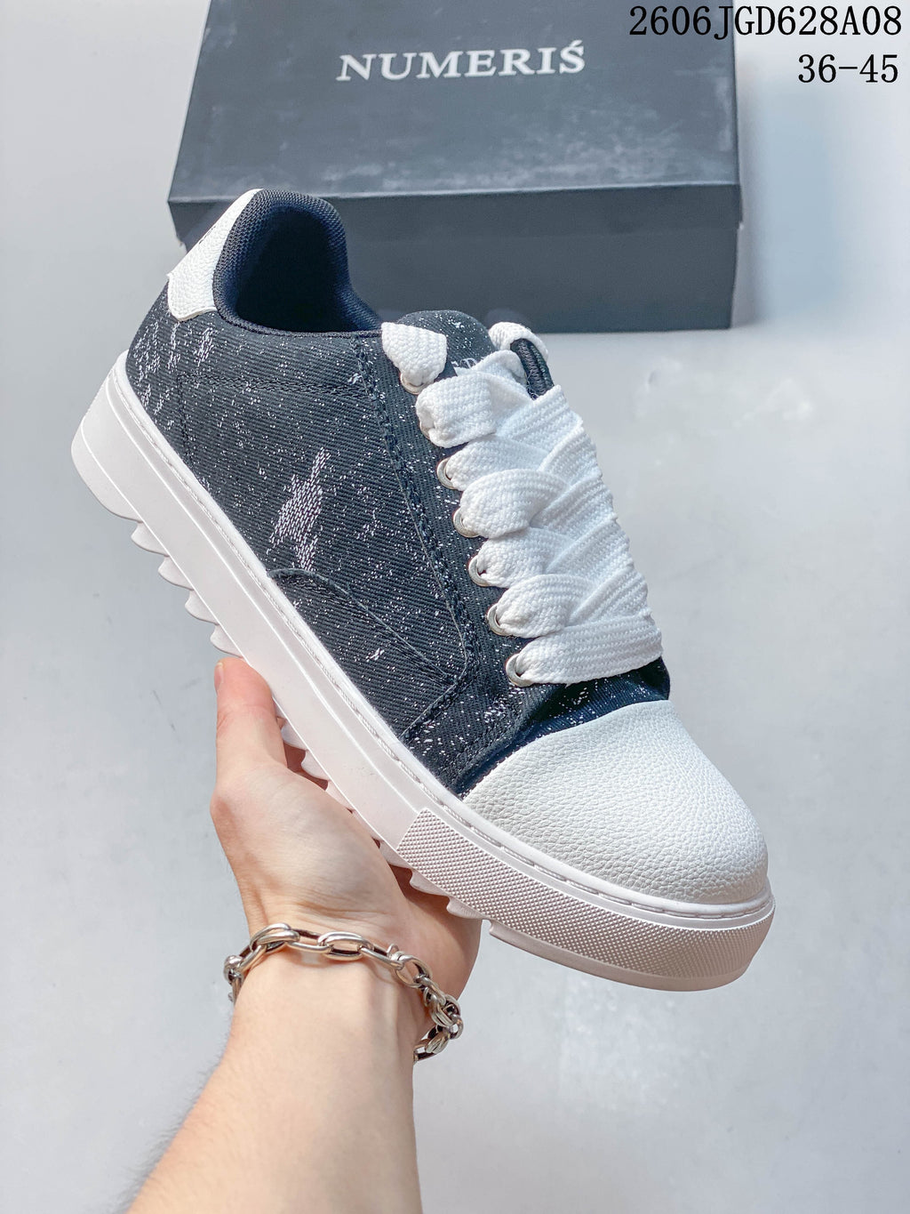 Charcoal sneaker with a white toe and sole and a subtle printed side panel.