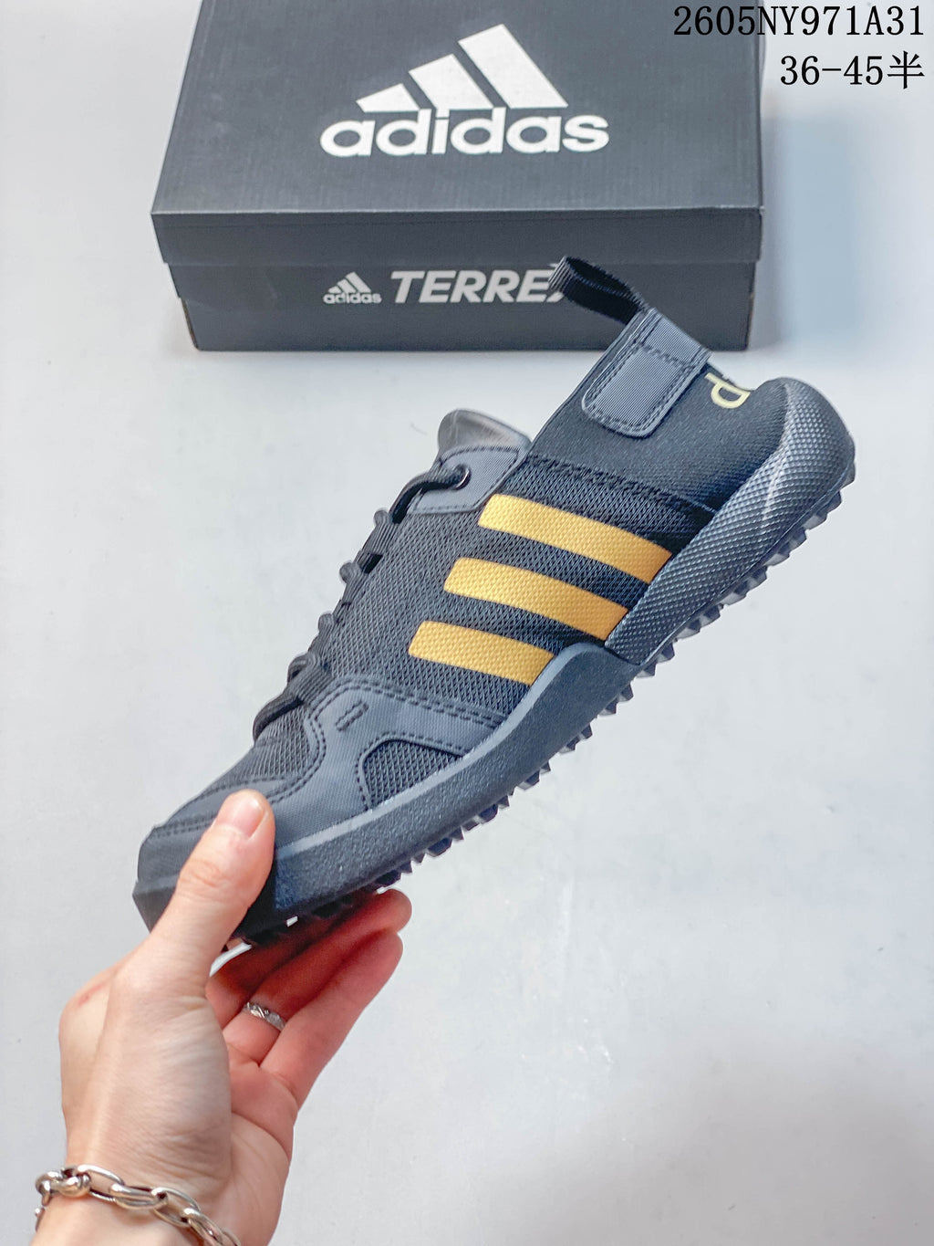 Side view of a dark gray lace-up shoe with yellow-orange stripes