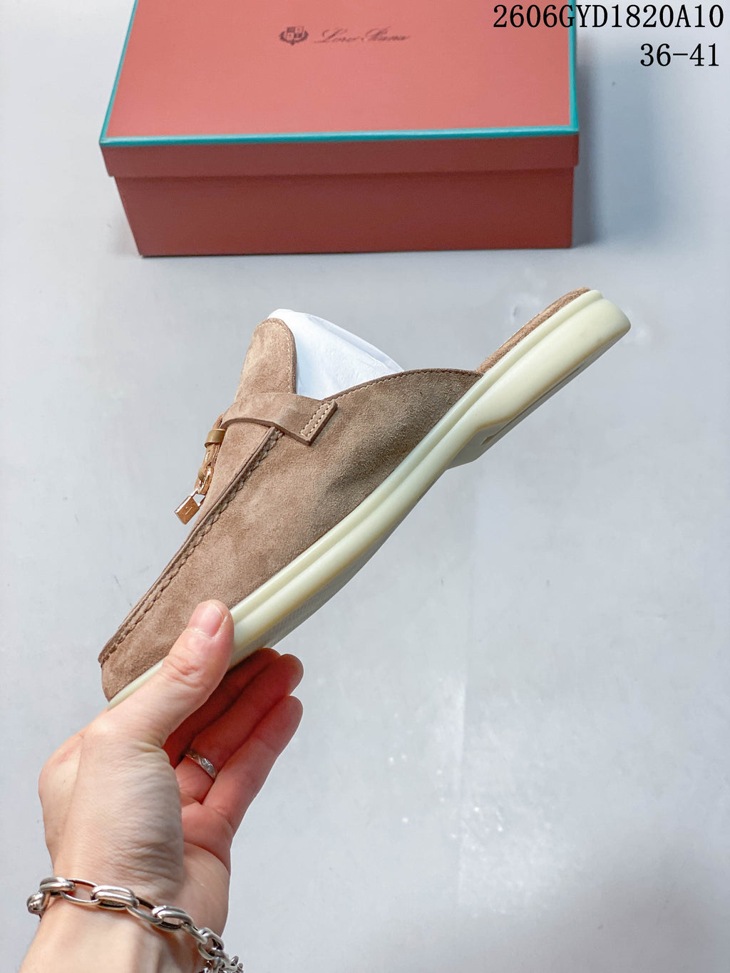Side profile of a taupe loafer mule with apron stitching and a light sole