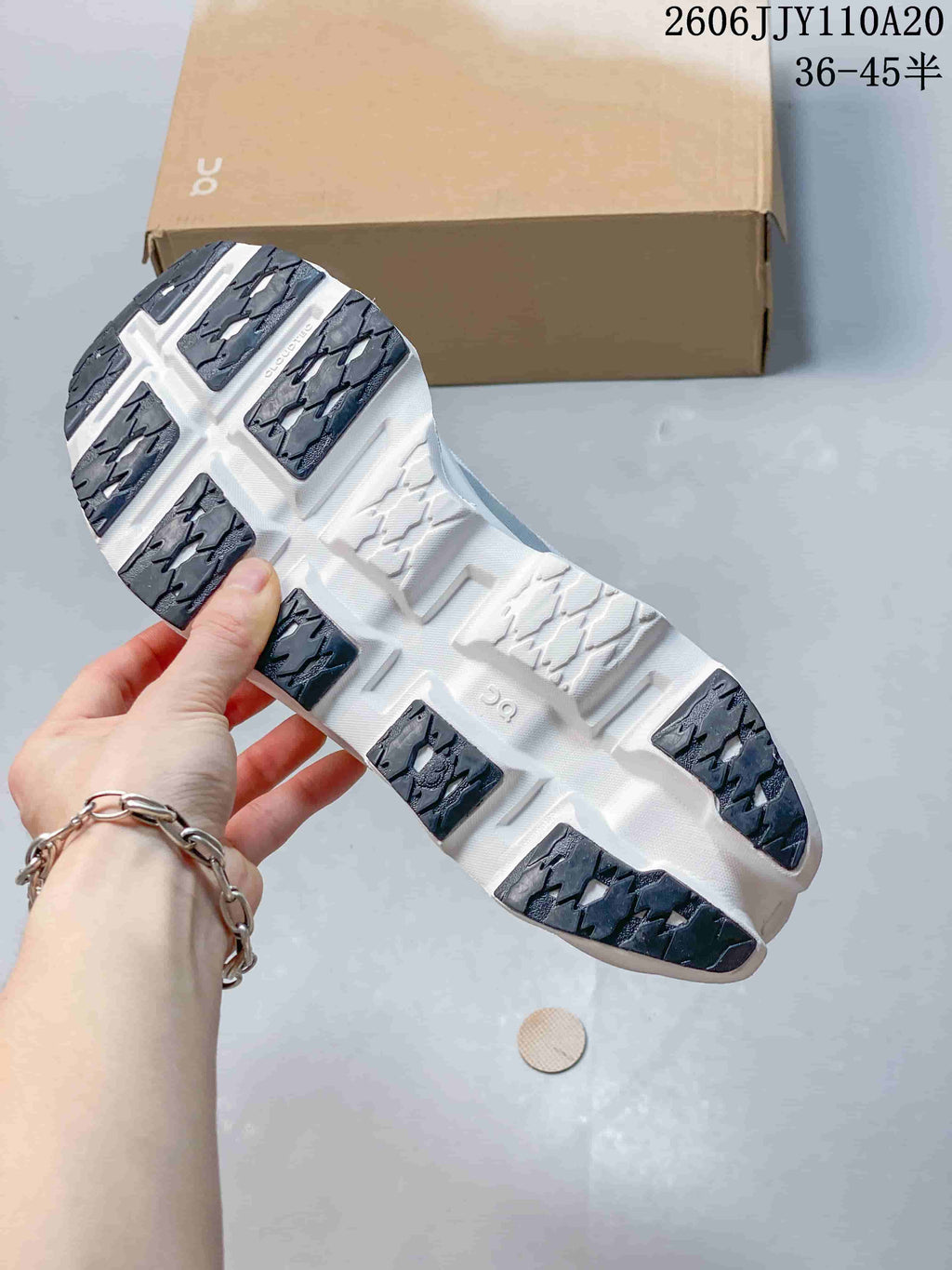 Underside of the On Cloudmonster 3 shoe showing white sole sections and dark tread areas