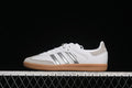 Side view of a white adidas Samba OG sneaker with silver stripes and a gum-colored sole