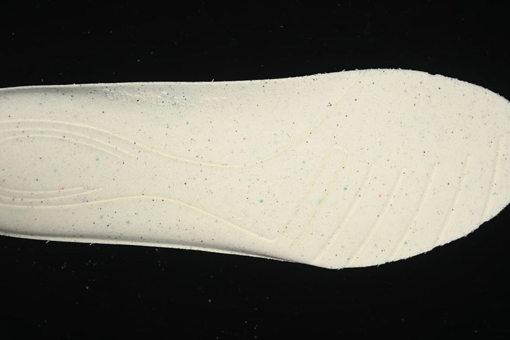 Close-up of the light-colored outsole section with small colored speckles.