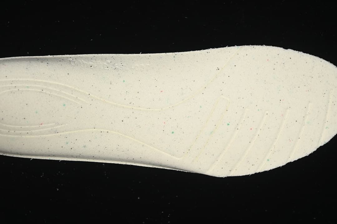 Close-up of the light-colored outsole section with small colored speckles.