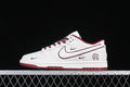 Side view of a white and burgundy Reigning Champ Nike SB Dunk Low sneaker