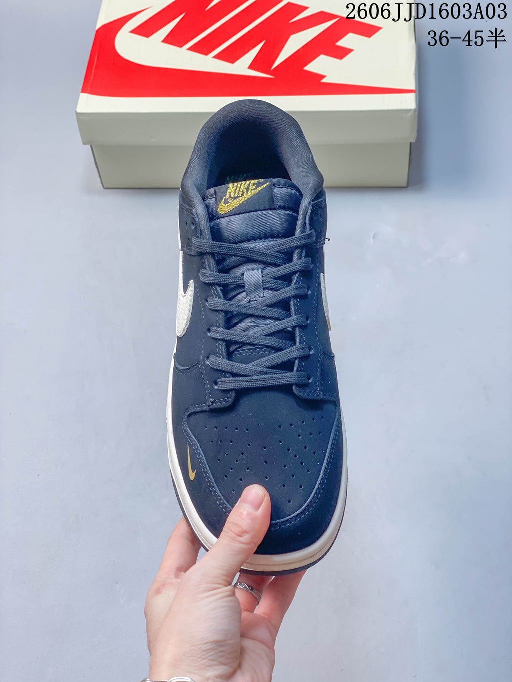 Top view showing navy laces, perforated toe, and gold tongue branding