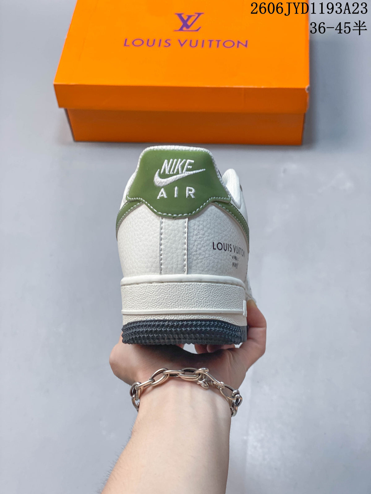 Rear view showing a green heel tab and white upper.