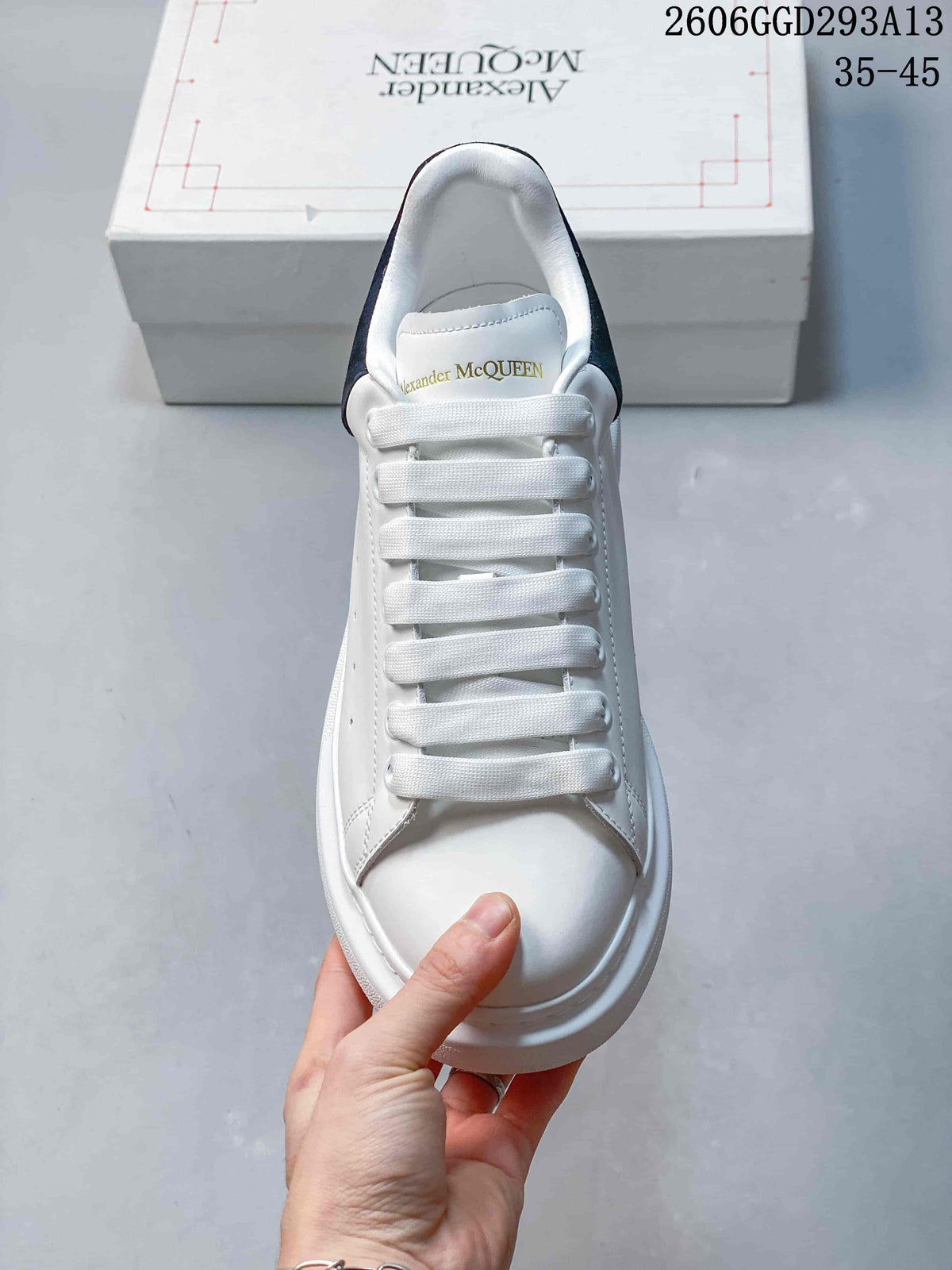 Front view of a white low-top sneaker with wide laces and a rounded toe