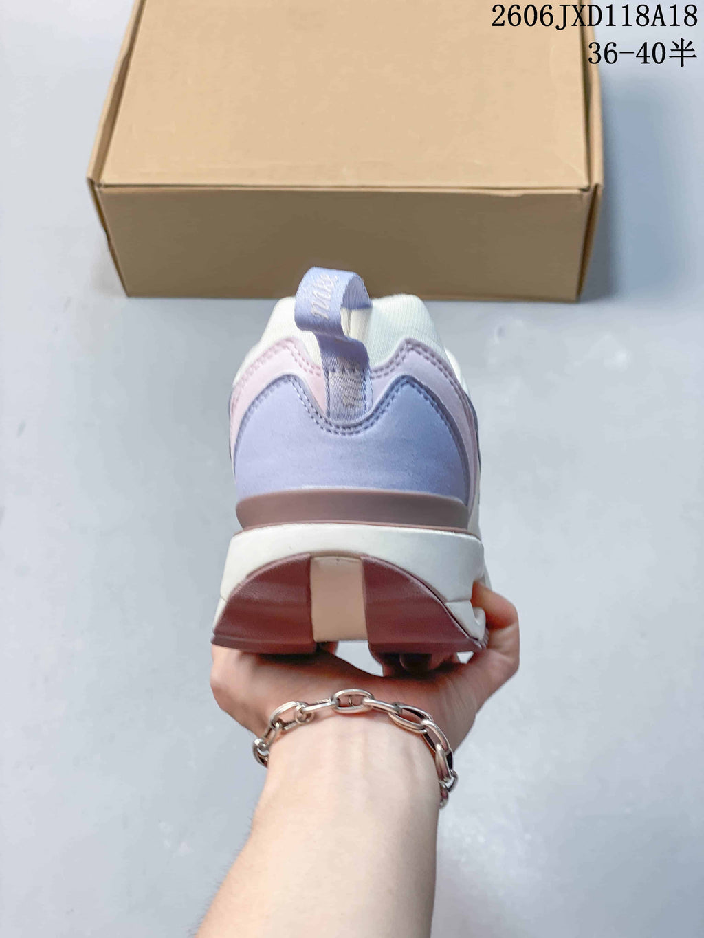 Rear view of the sneaker showing lavender heel panels and a layered heel sole.