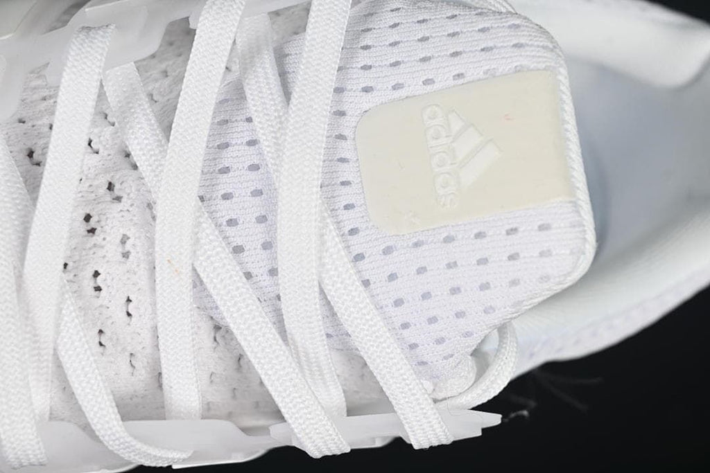 Close-up of the Adidas tongue label and white laces.