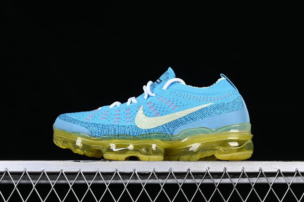 Side view of the blue Nike Air VaporMax 2023 Flyknit with a pale Swoosh and translucent yellow sole.