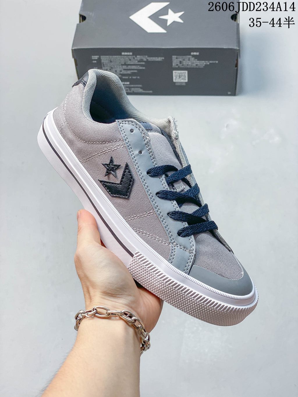 Angled side view of the gray and navy low-top sneaker
