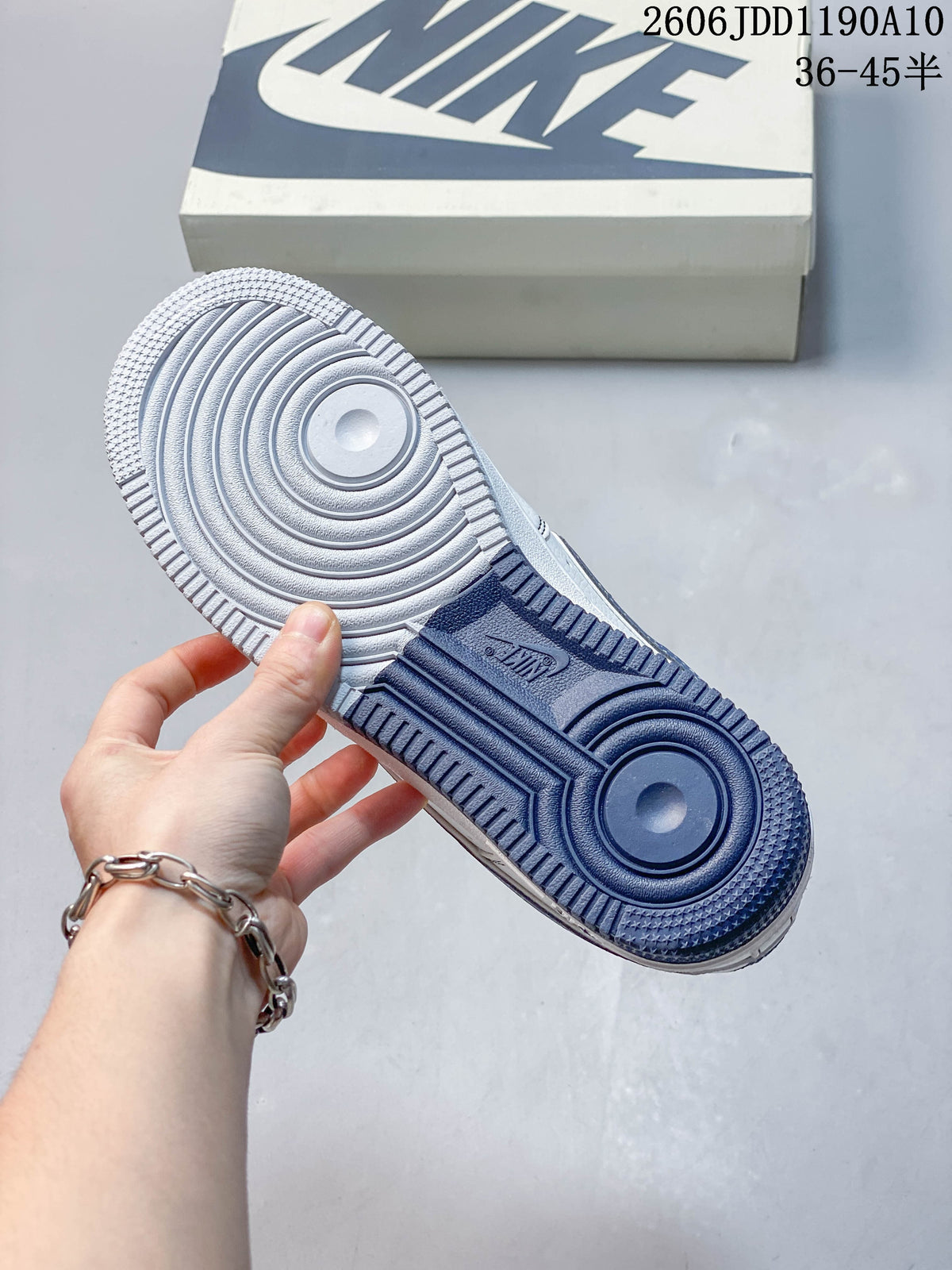 Underside of the sneaker showing a textured outsole with white and blue sections