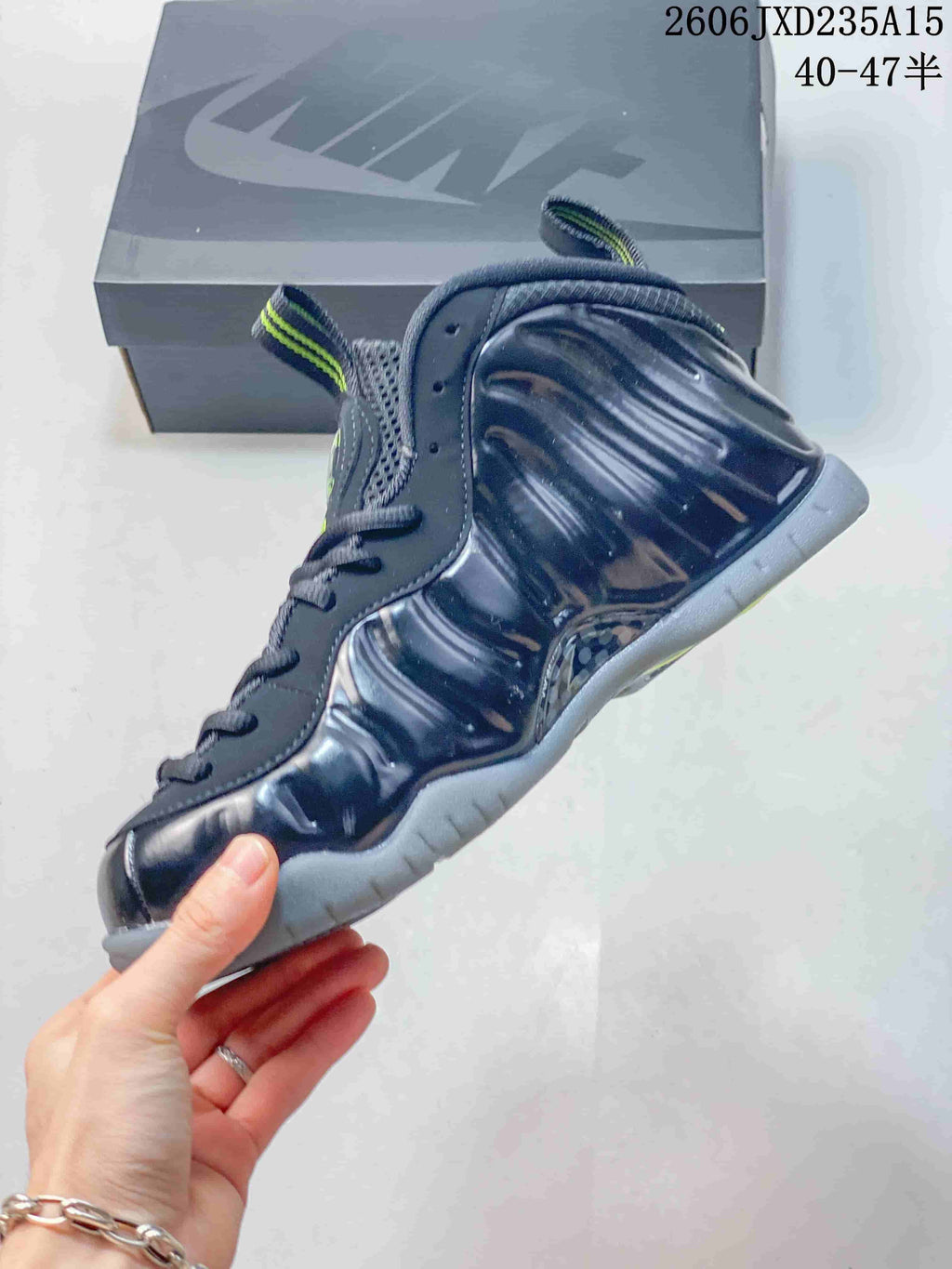 Side view highlighting the molded ridged upper and gray sole of the dark Foamposite One shoe.