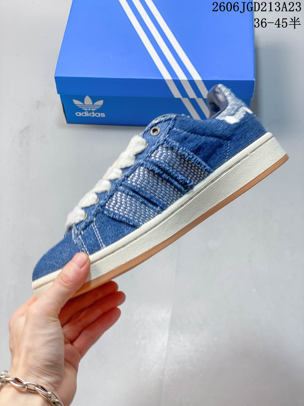 Side view of the blue low-top sneaker with textured panels, contrast stitching, and gum outsole.