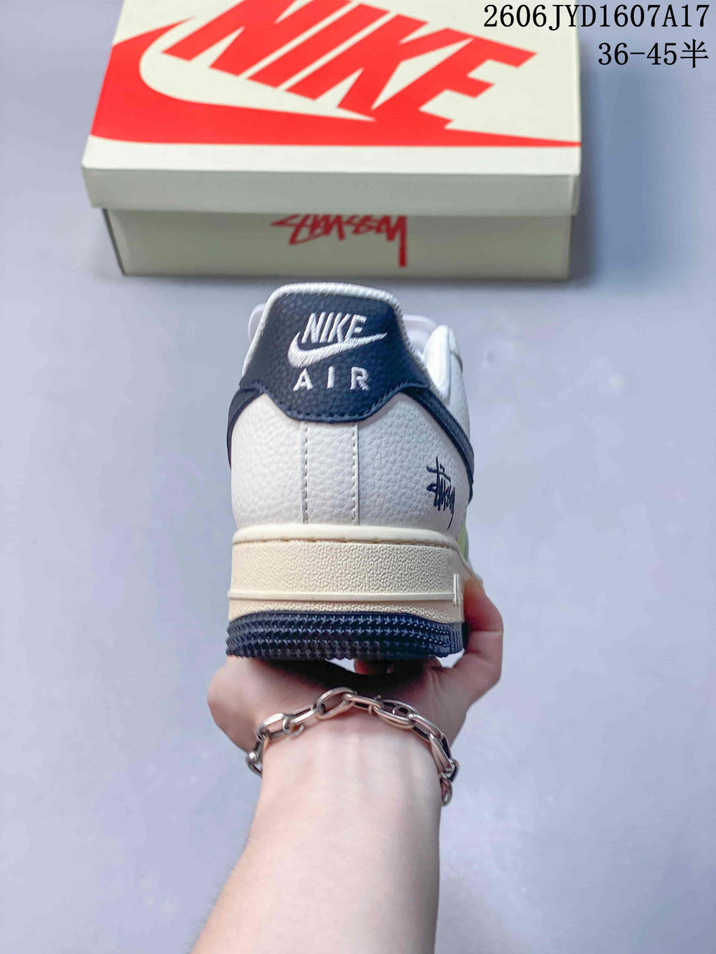 Rear view showing a navy heel tab, white upper and off-white midsole.