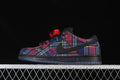 Side profile of plaid Nike SB Dunk Low sneakers with black Swoosh and dark sole.