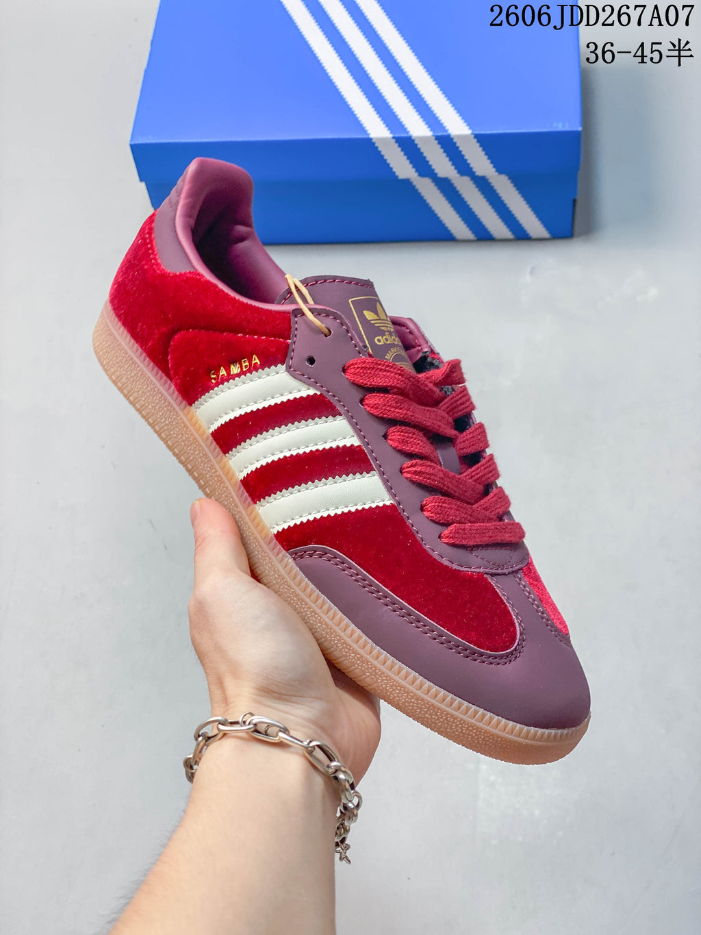 Angled side view showing the red upper, mauve overlays, white stripes, gum-colored sole, and Samba side marking.