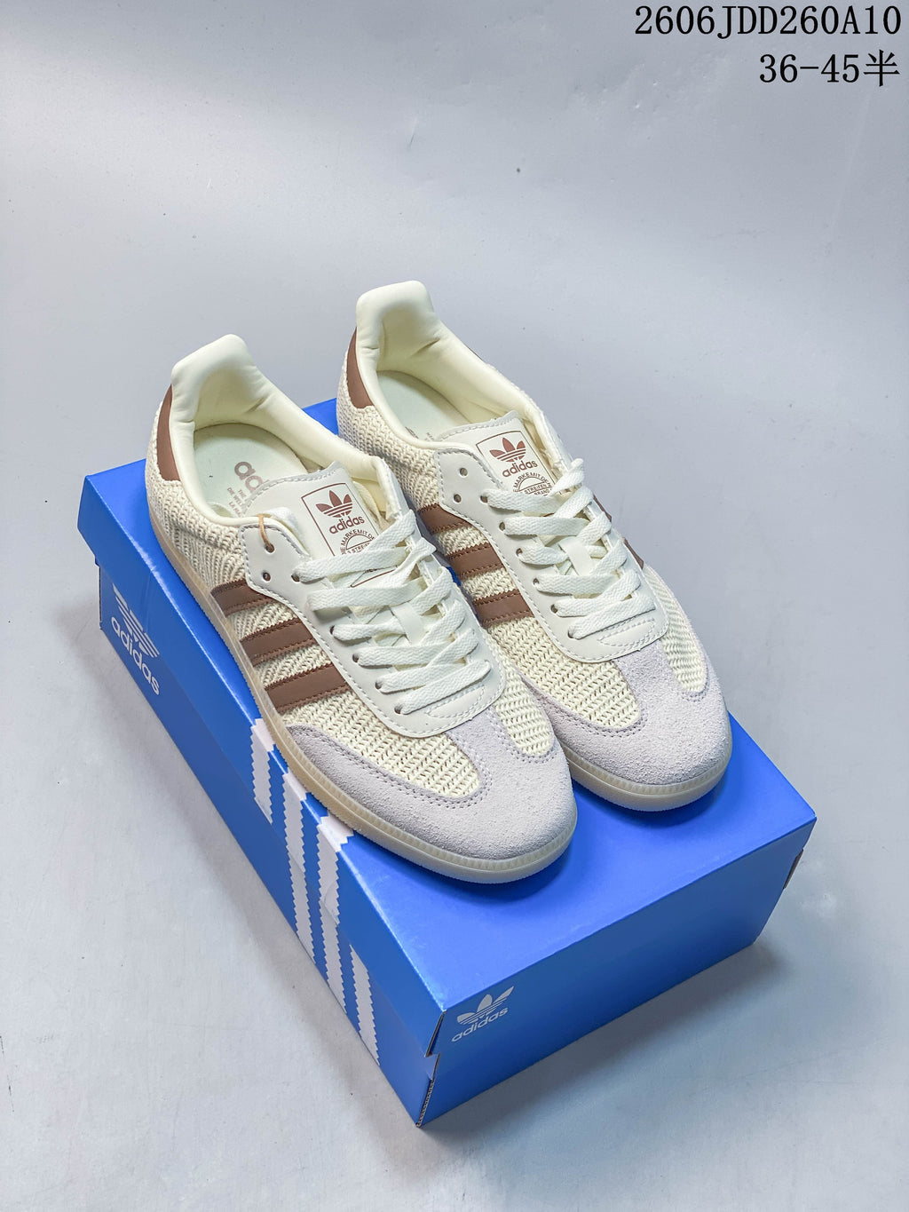Beige and brown adidas Samba OG low-top sneakers shown on a blue box