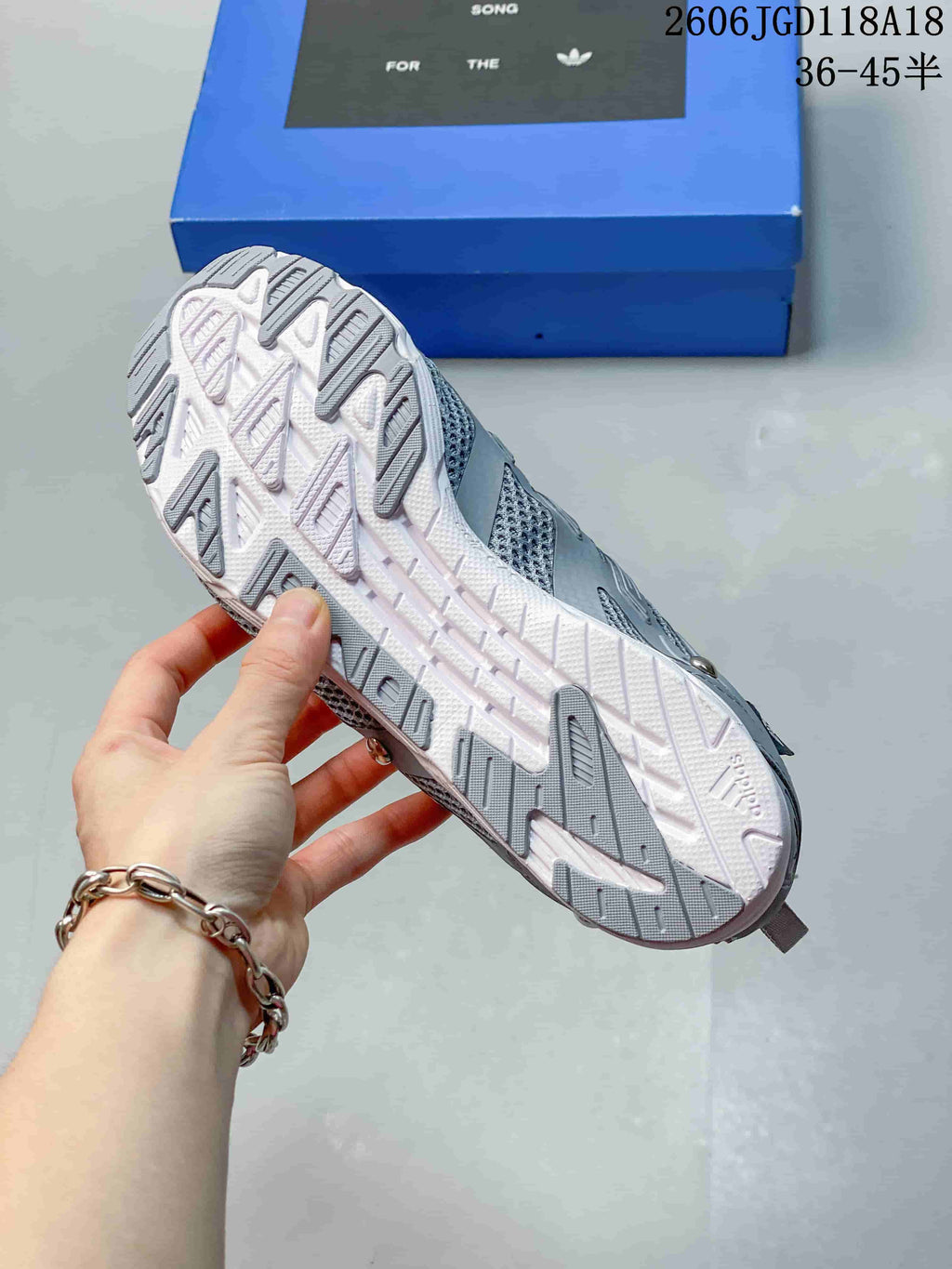 Outsole view showing the white and grey tread of a grey sneaker