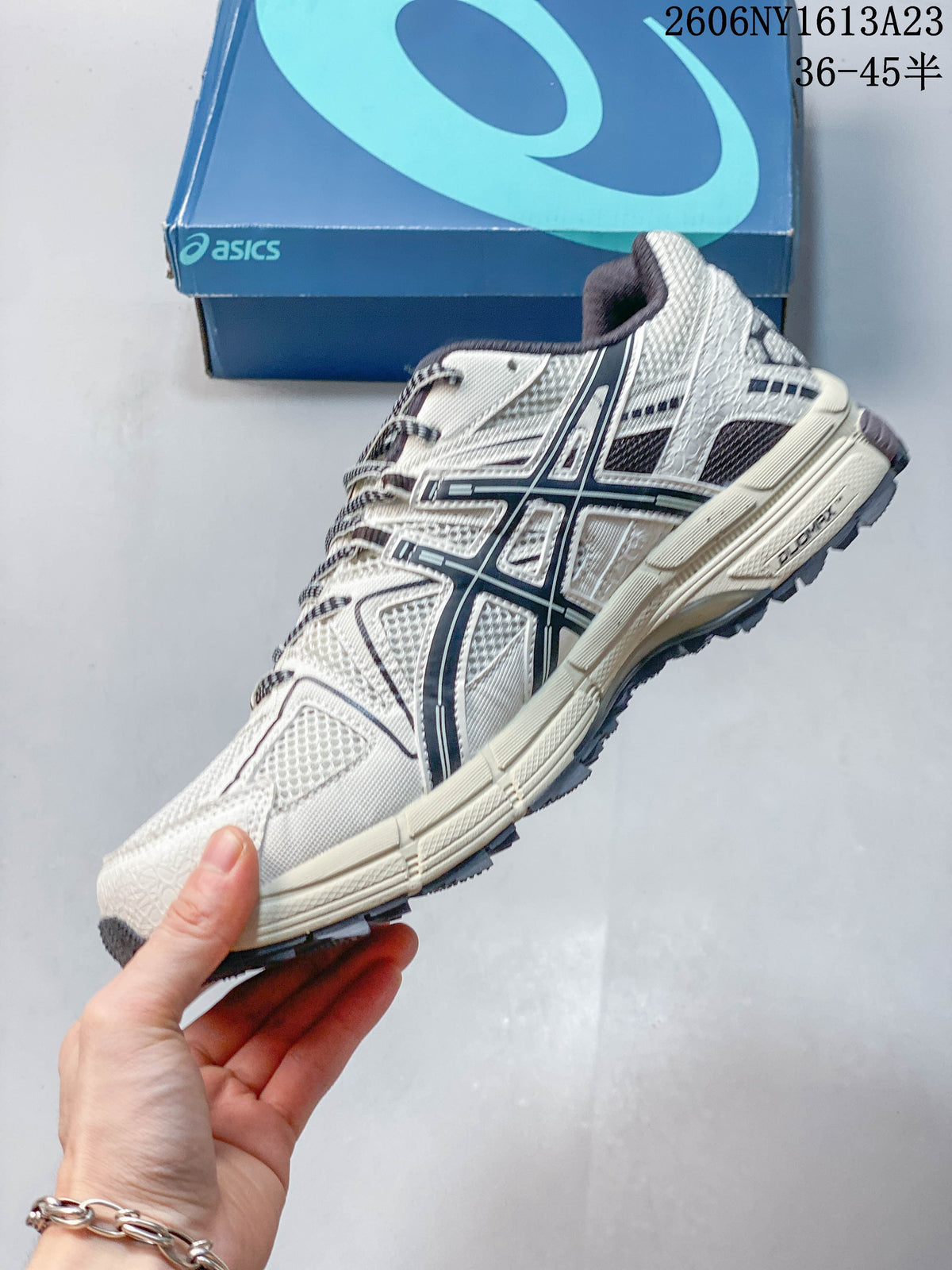 Side view of a cream and navy ASICS Gel-Kahana 8 shoe