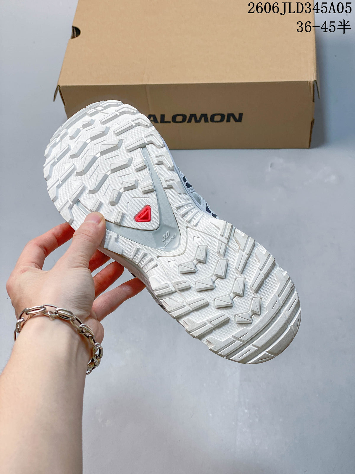 Close-up of the lugged outsole on a white Salomon XT-3D shoe