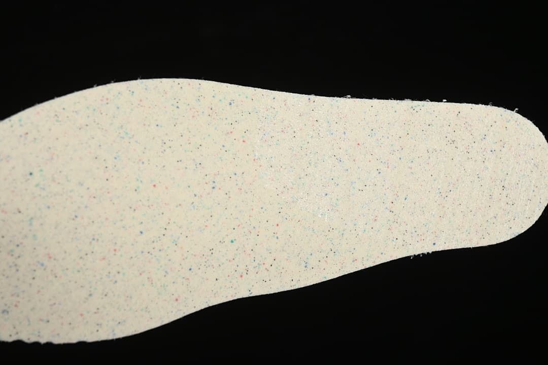 Close-up of a light-colored insole with small multicolor flecks