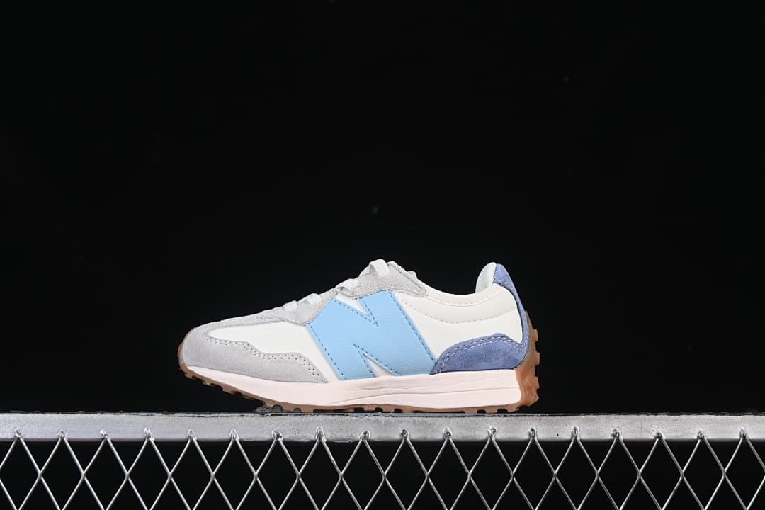 Side view of the sneaker showing the light blue logo, grey overlays, and gum-colored outsole.