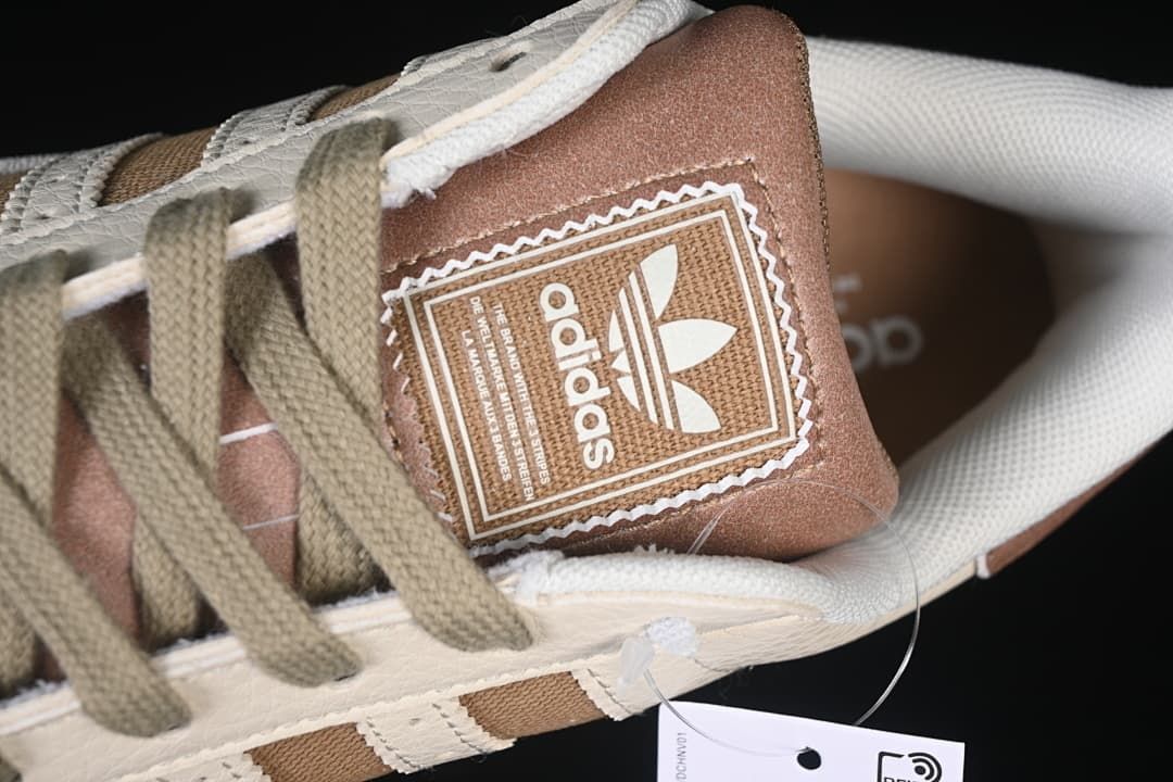 Close-up of the tongue label, olive-toned laces, and upper.