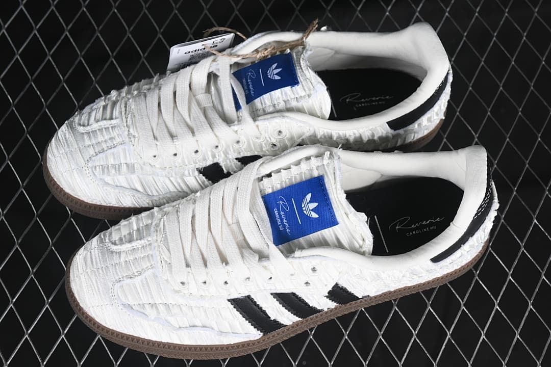 Pair of white Samba OG sneakers with black stripes and dark brown soles