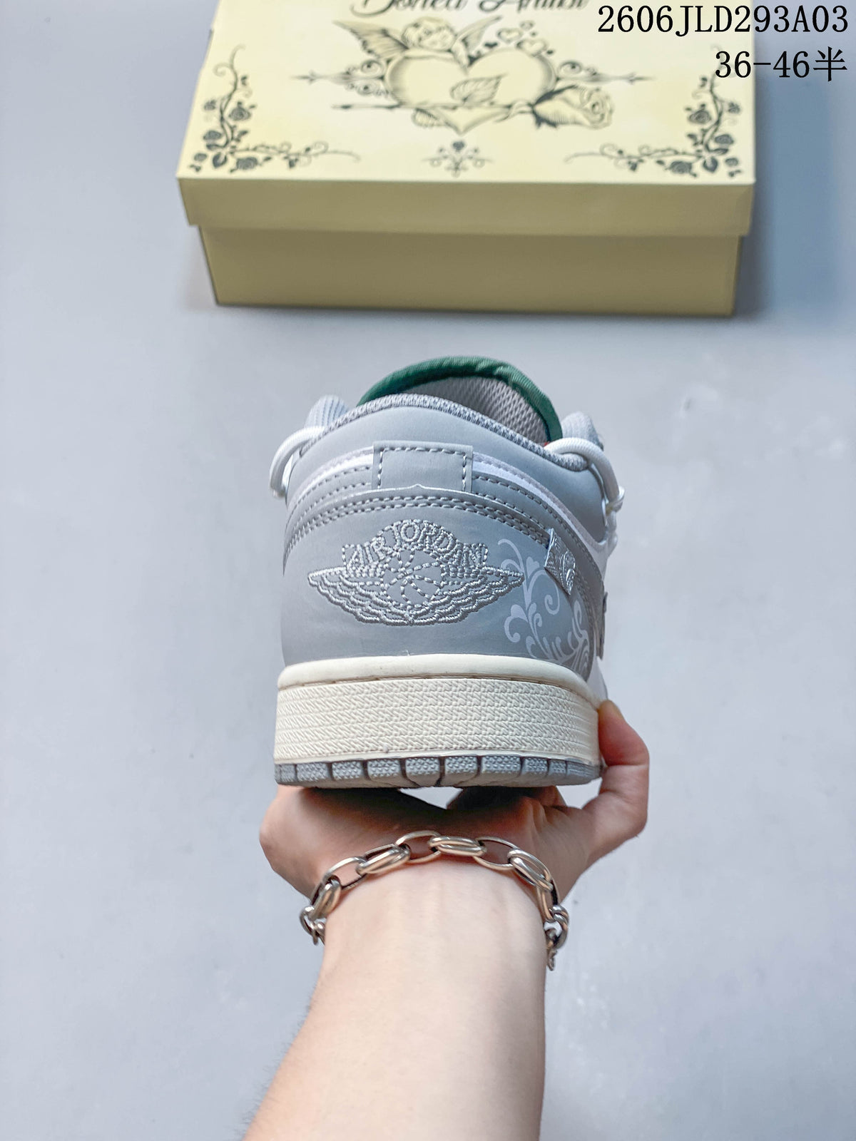 Rear view of a white and gray sneaker showing embroidered Jordan branding and decorative side graphics; overlay shows a size range.