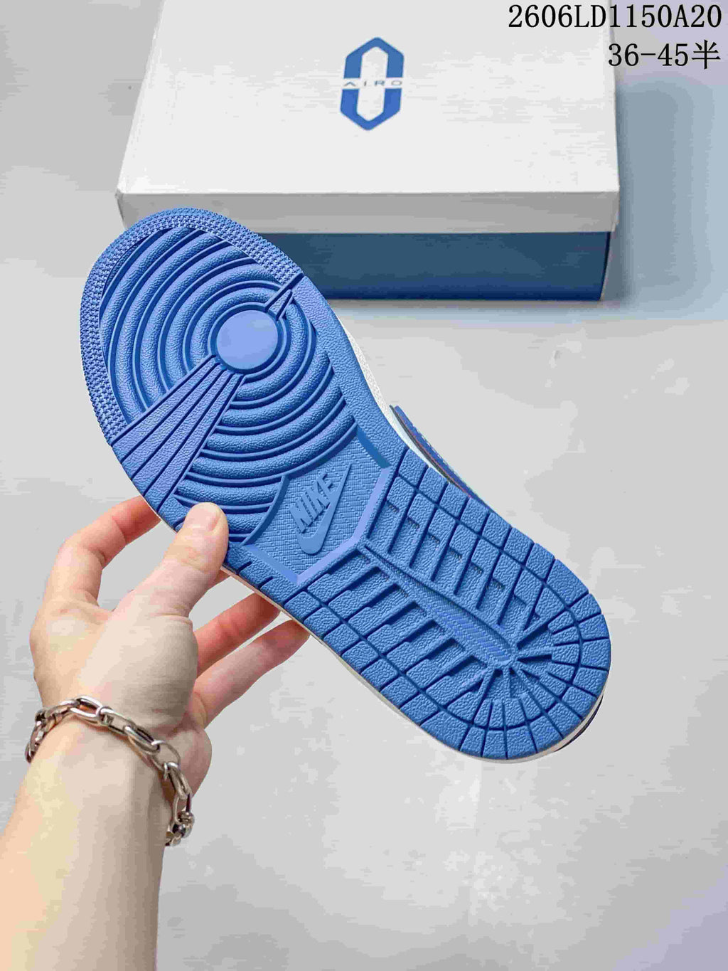 Blue outsole of a low-top sneaker, with the shoe box in the background.