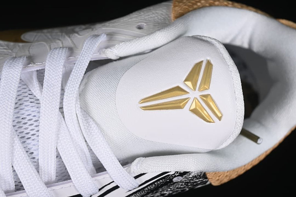 Close-up of the white tongue with a gold Kobe logo and white laces