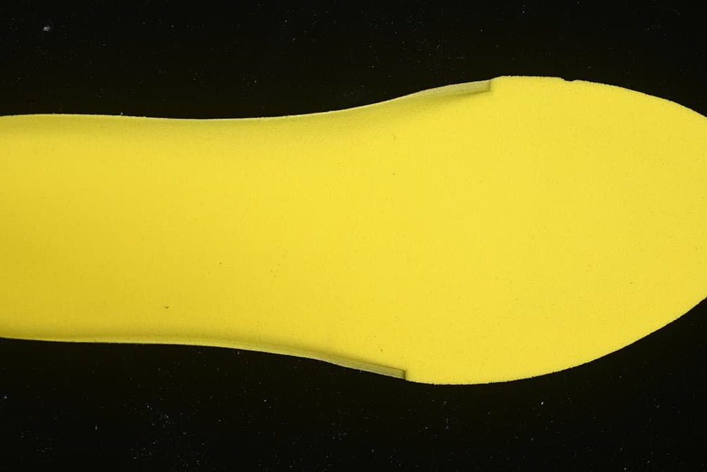 Yellow shoe insert shown against a dark background