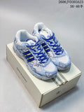 Pair of white and light-blue adidas Response CL sneakers with royal-blue laces on a Bad Bunny box