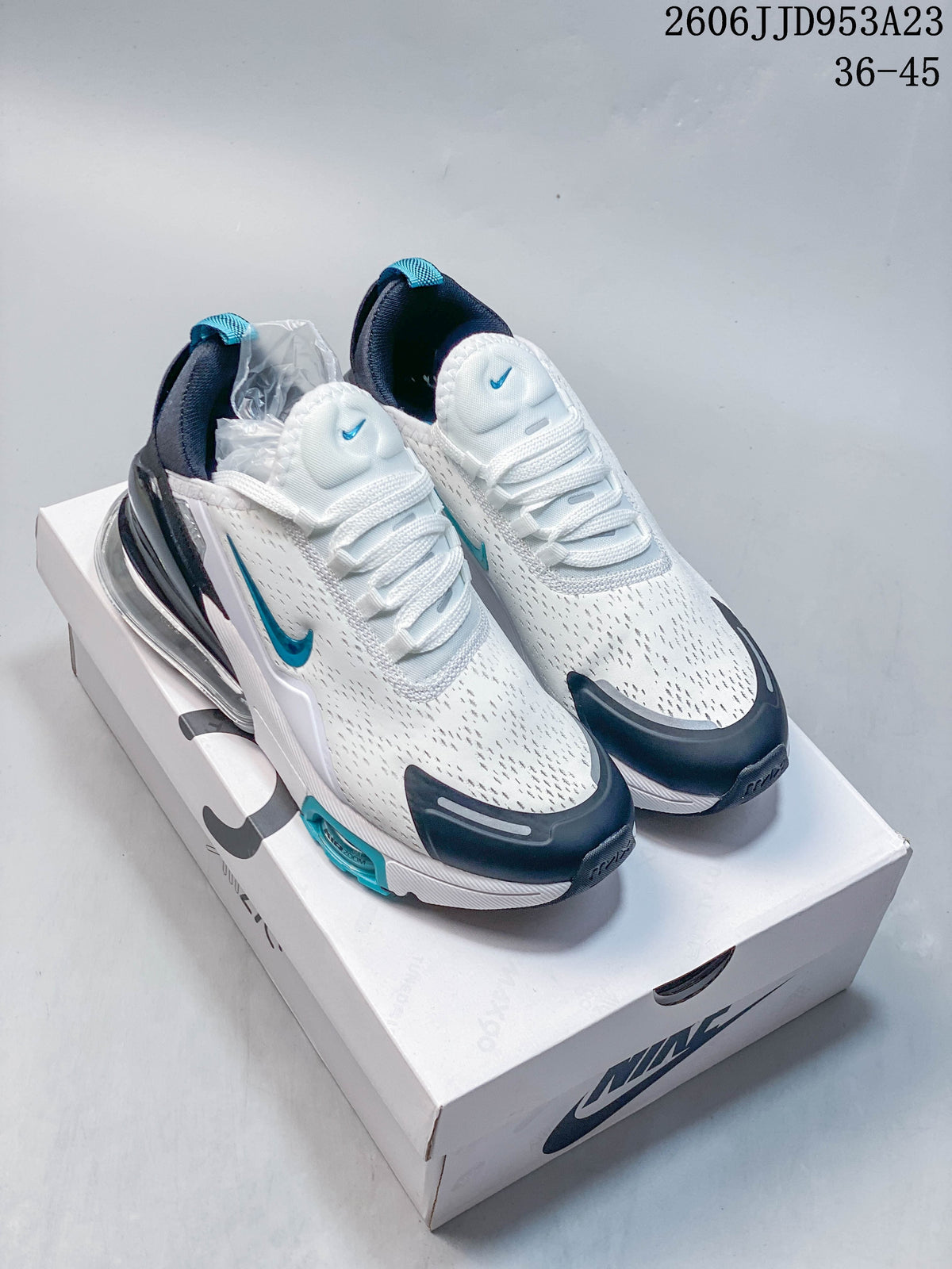 White Nike Air Max 270 sneakers with teal and dark navy accents, shown on a box.
