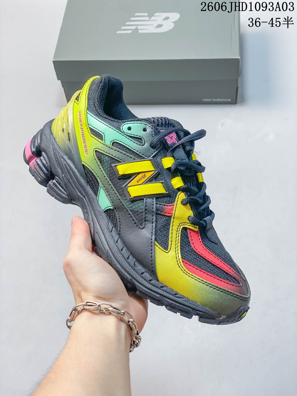 Dark gray New Balance 1906U sneaker with yellow, mint and pink accents