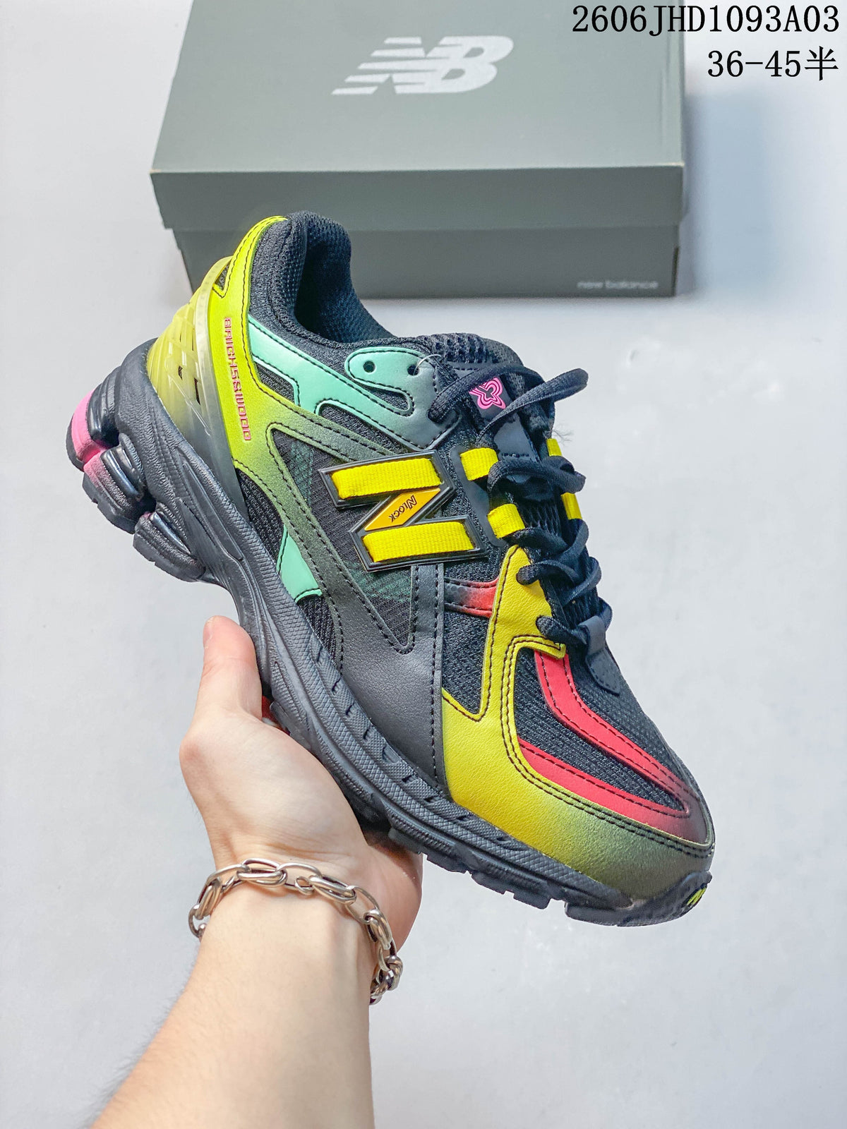 Dark gray New Balance 1906U sneaker with yellow, mint and pink accents