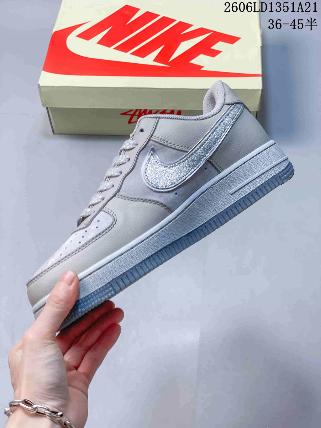 Side view of a light gray Nike Air Force 1 with a textured silver-toned Swoosh