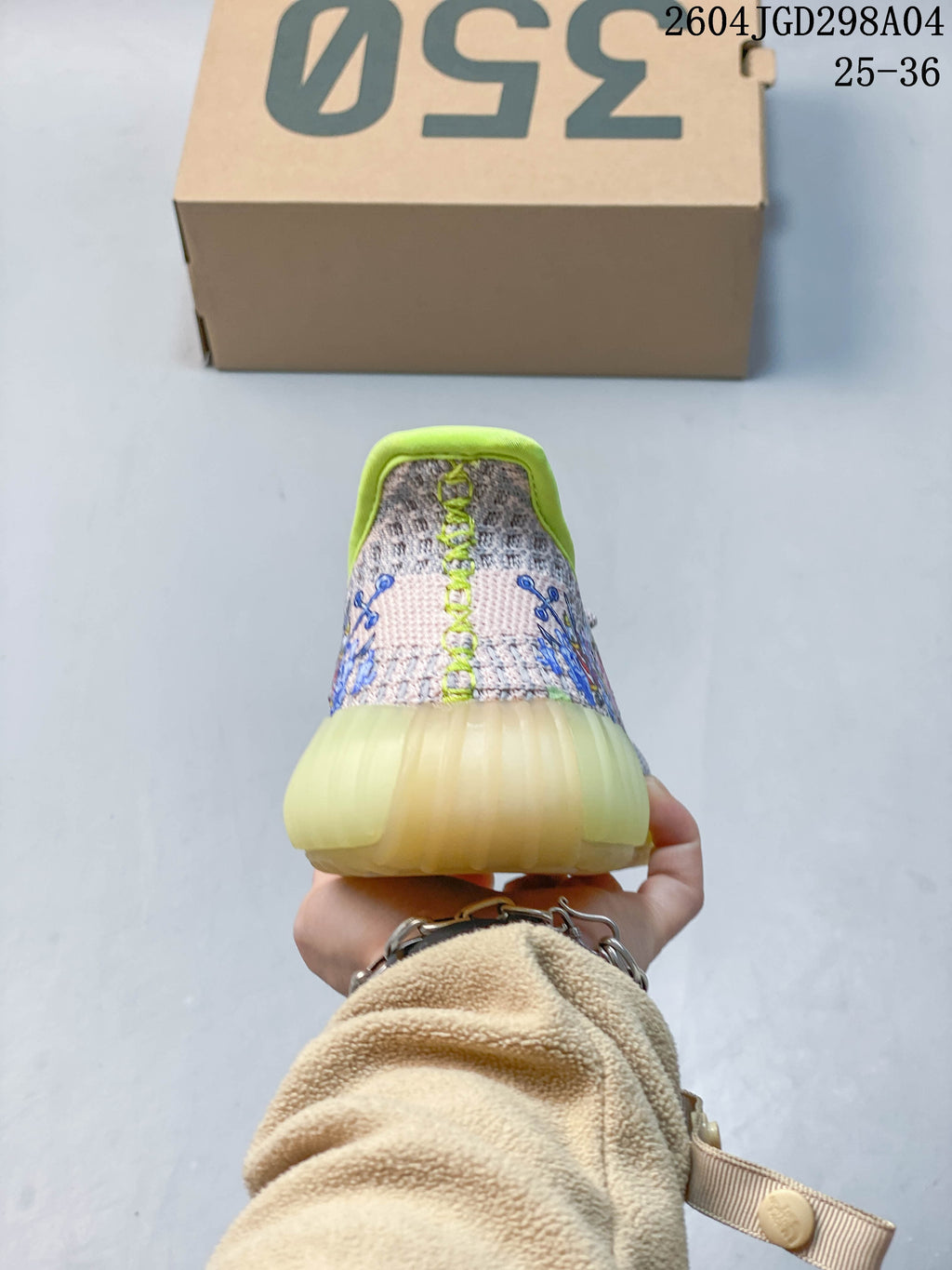 Rear view showing the lime-green heel trim and cartoon graphics on the upper.