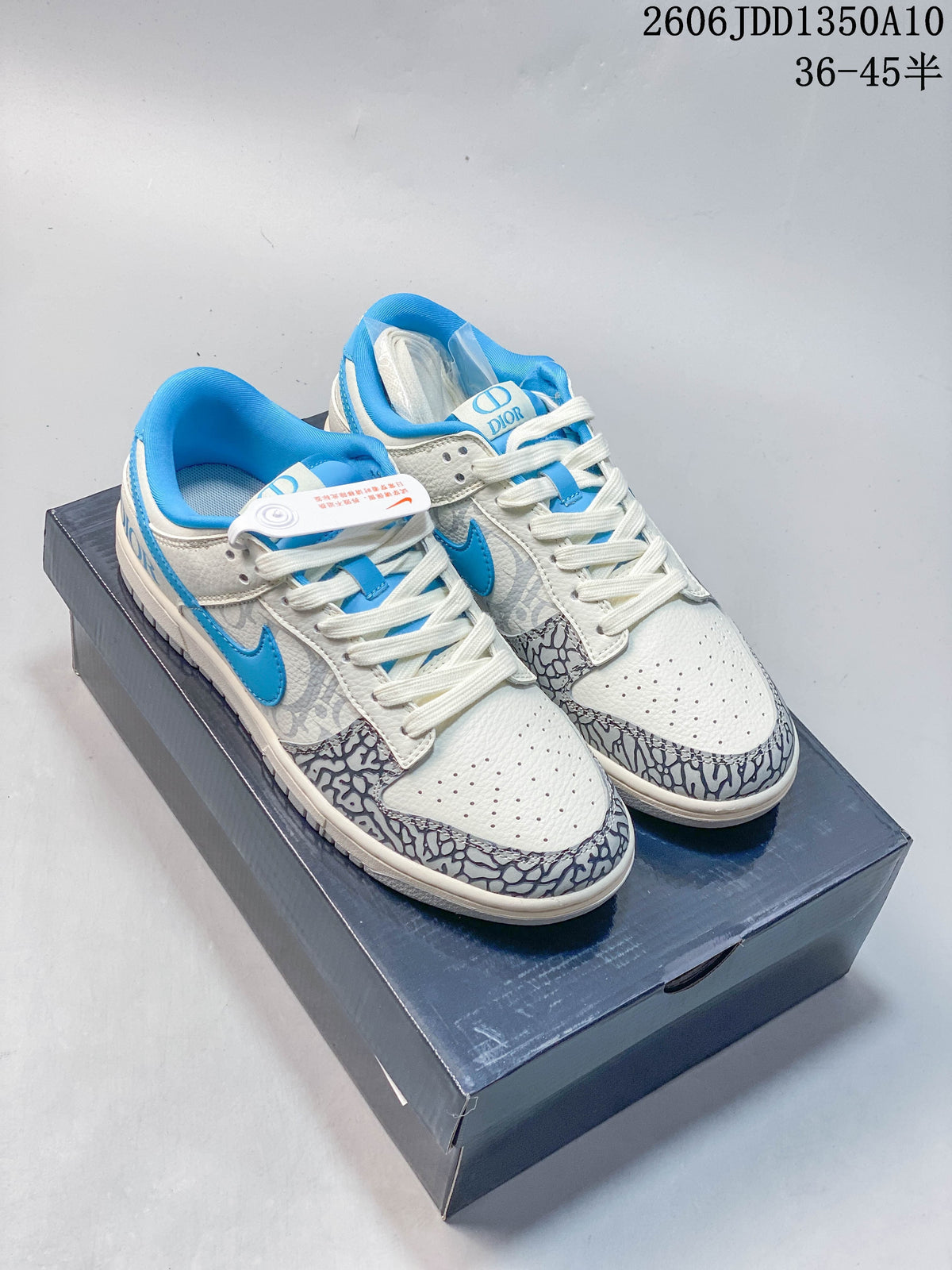 Pair of white and blue low-top sneakers with gray patterned panels, shown from above.