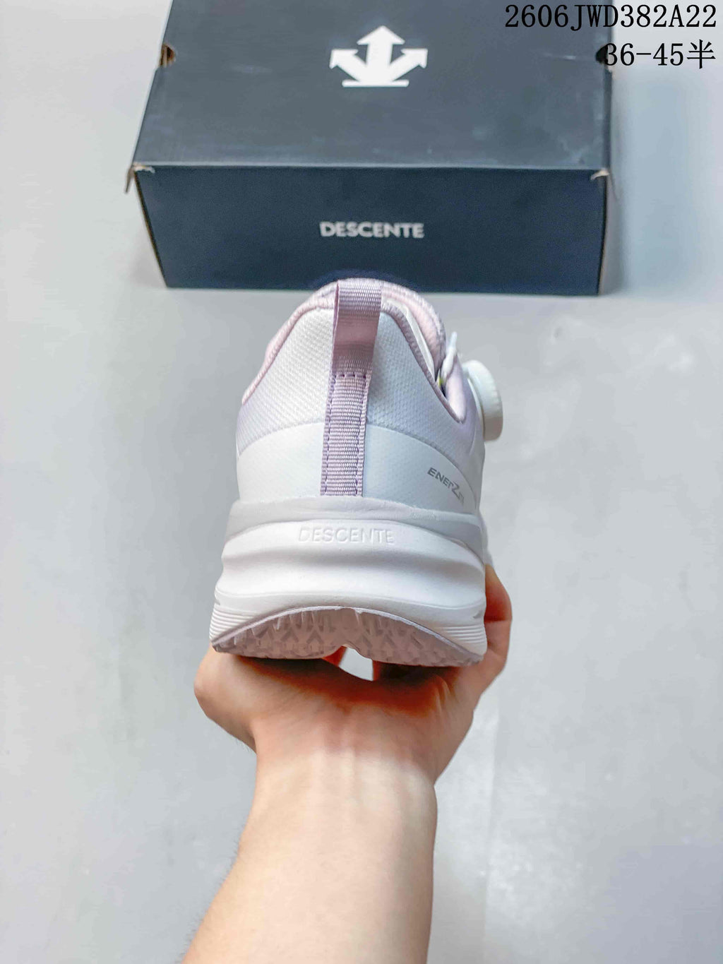 Rear view showing the heel, pull tab, and thick sole of the DESCENTE sneaker