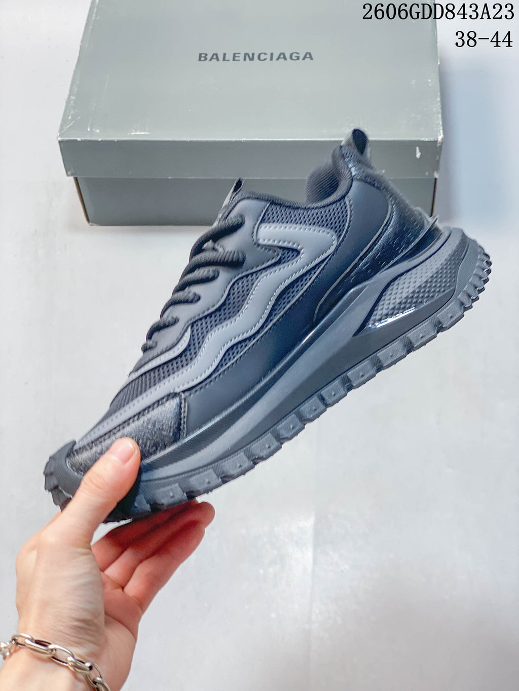 Side view of the gray sneaker with layered panels and thick outsole