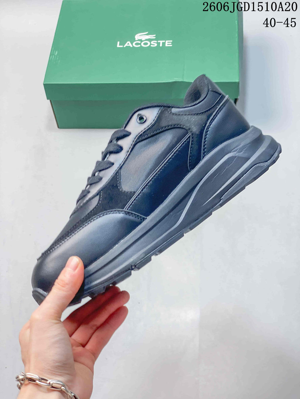Side profile of a dark navy Lacoste low-top sneaker with layered panels.