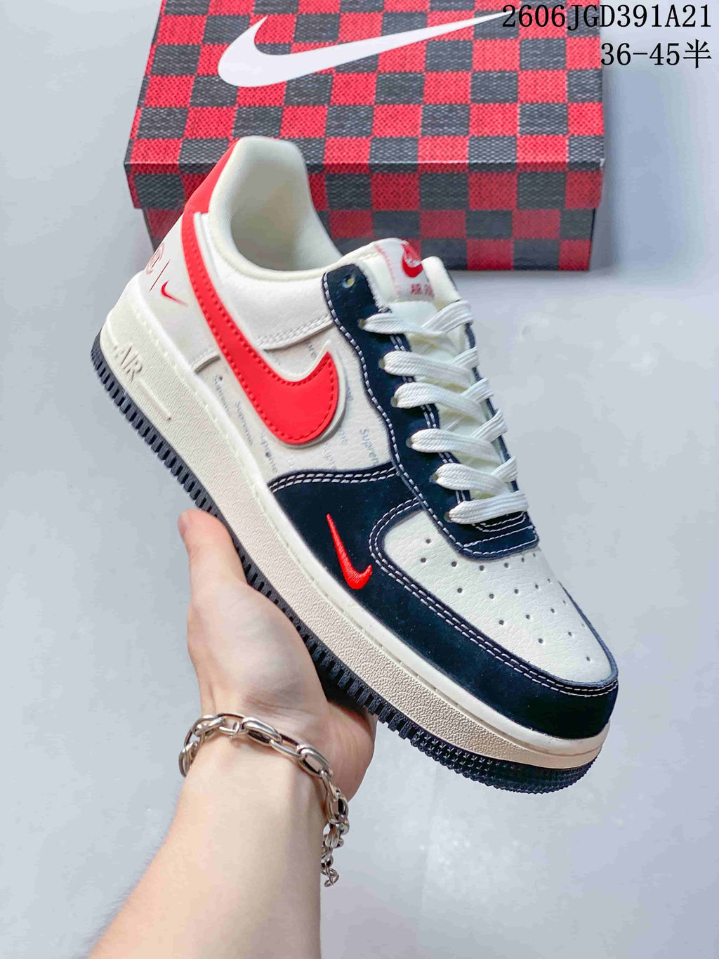 Side view of a white sneaker with navy and red accents and perforated panels.