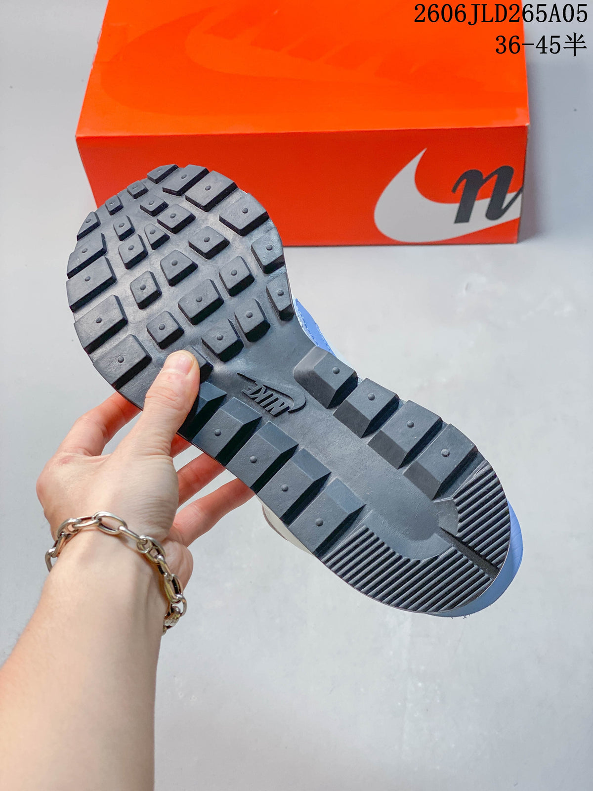 Close-up of the dark lugged outsole on a Nike Sacai LDWaffle sneaker