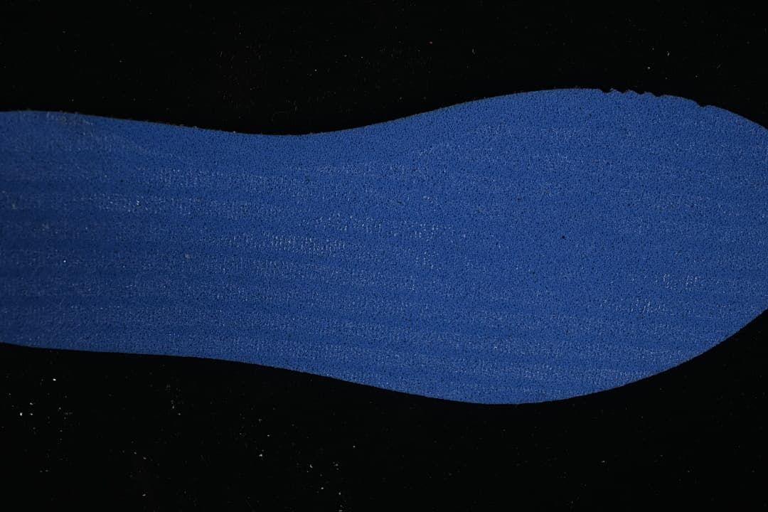 Blue textured shoe insert displayed against a dark background