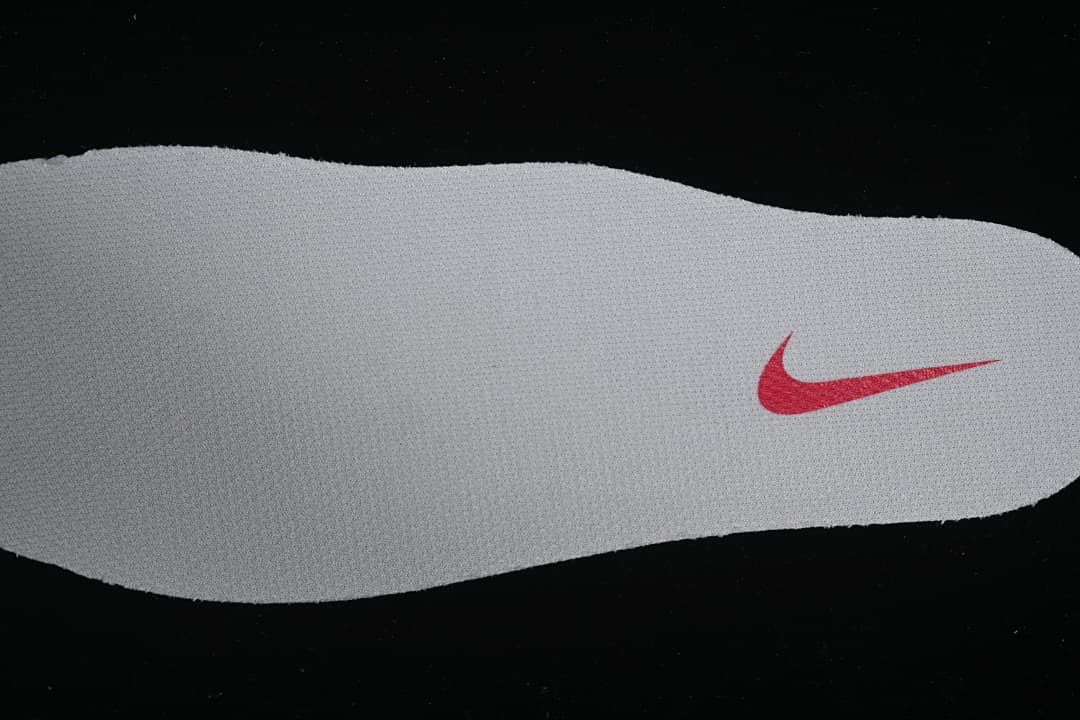 Close-up of a white insole with a red swoosh.