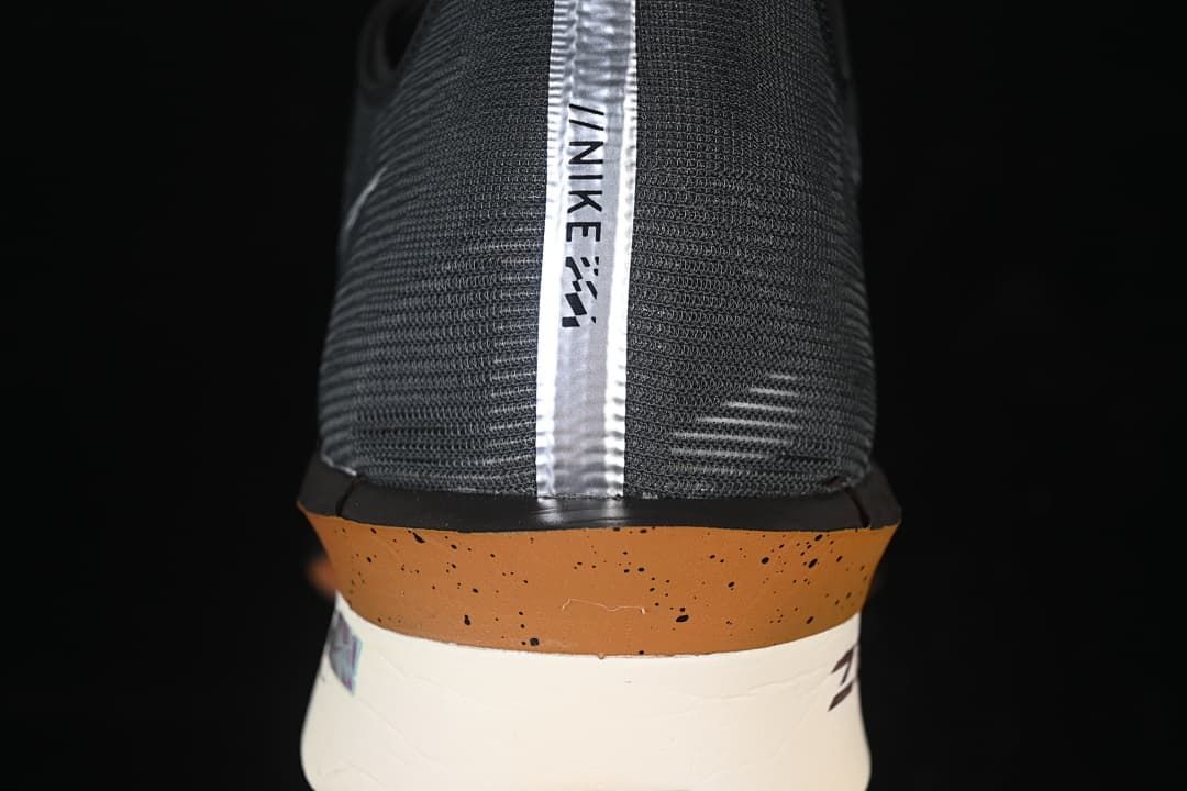 Rear view showing the shoe heel, vertical strip, and copper-toned midsole accent.